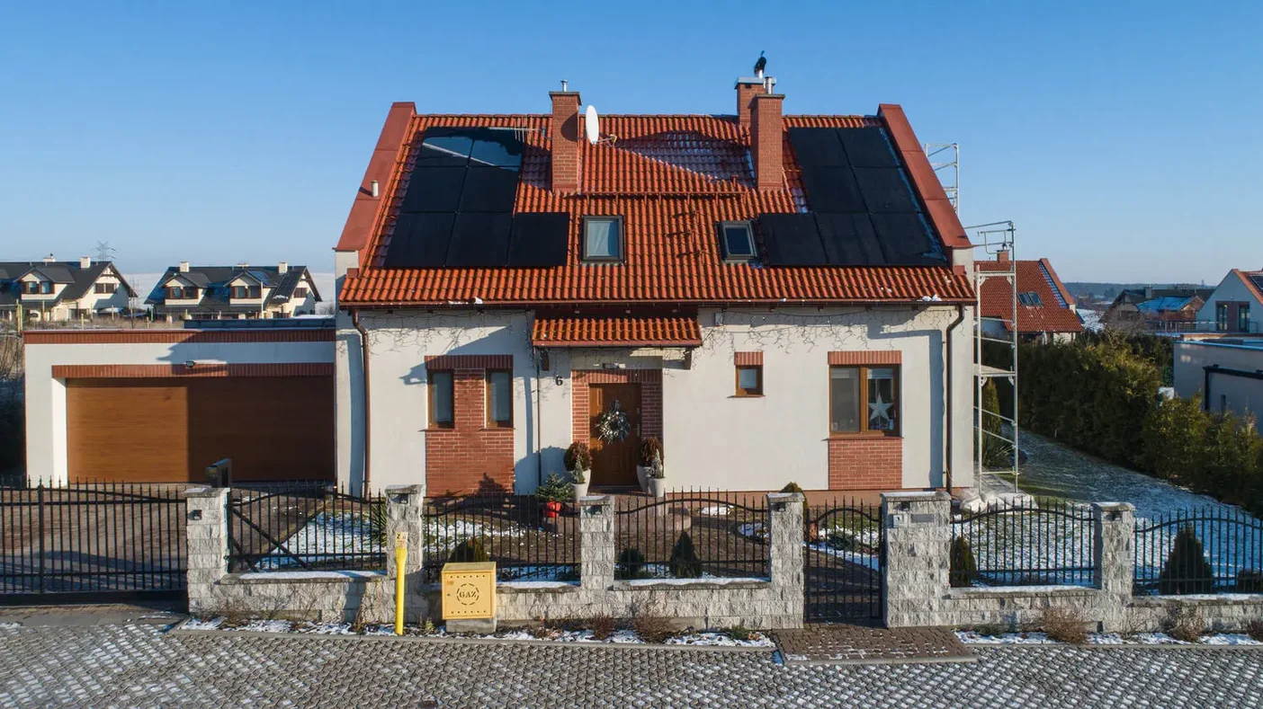 14 modułów fotowoltaicznych na czerwonej dachówce - widok od frontu domu